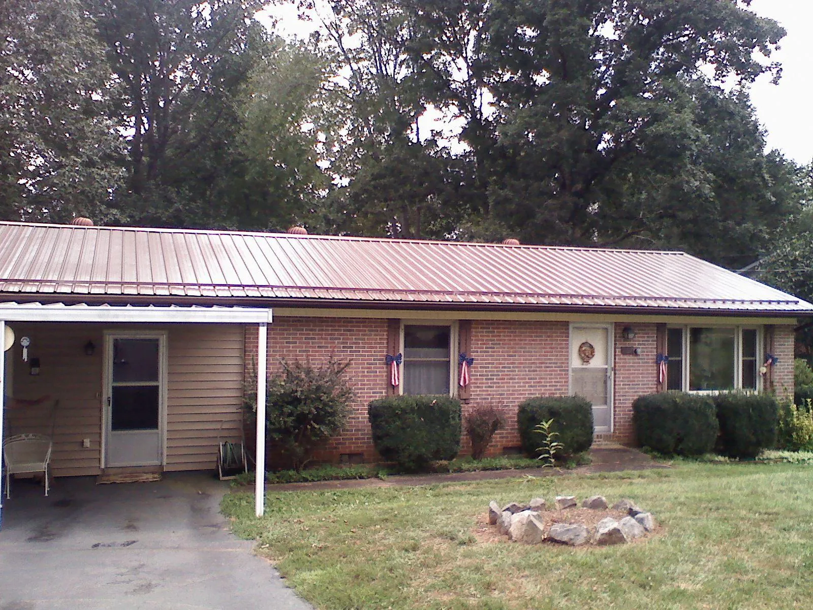Bronze metal roof and carport on a brick ranch home — Roof Repair work by our crew in Canandaigua